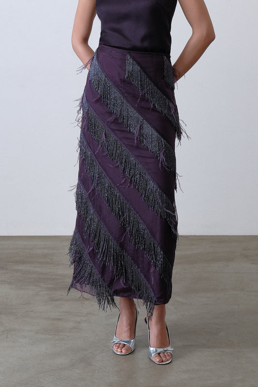 Close up of hand embroidered beaded fringe and feather detail on deep plum skirt