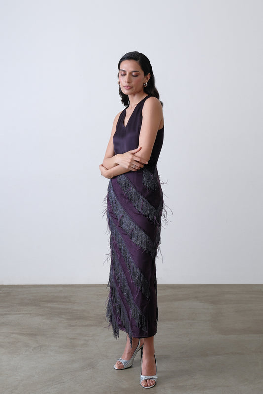 Side view of deep plum layered skirt with beaded fringe and feather accents