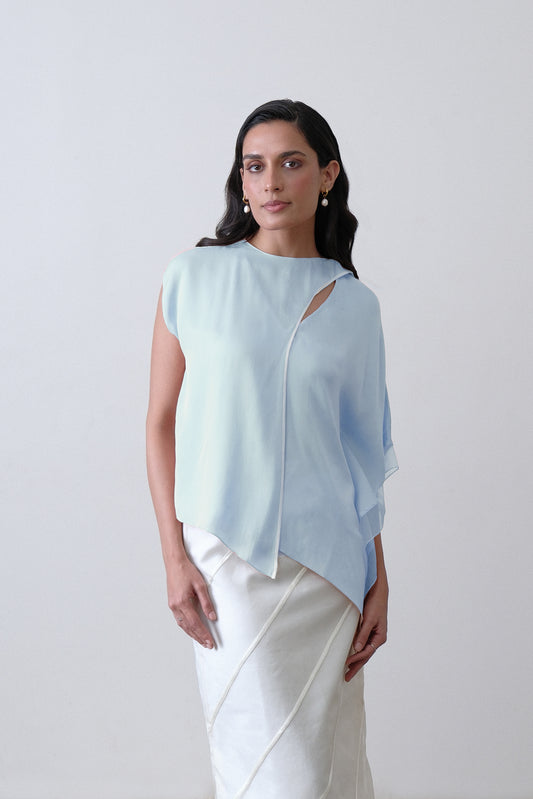 Close up of draped scarf detail with white piping and organza trim on powder blue silk top