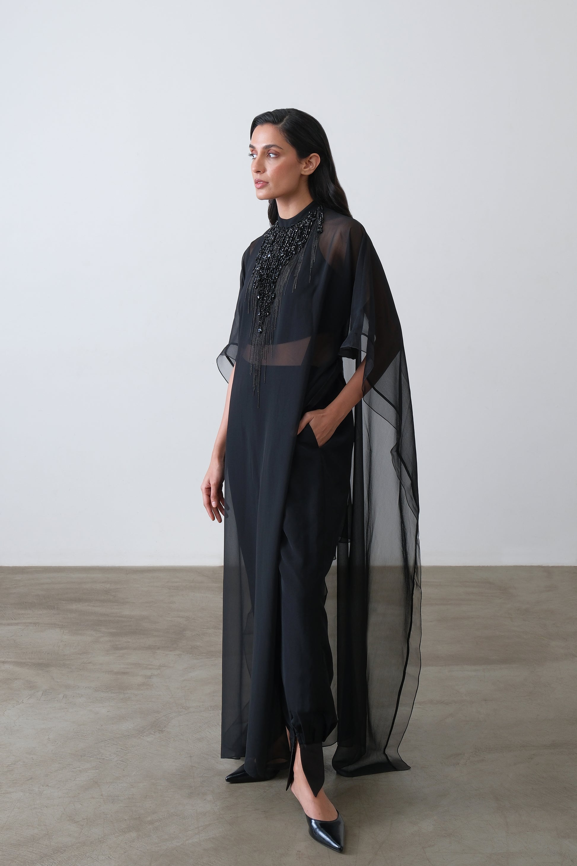 Black georgette cape shown at a three quarter angle with beaded neckline
