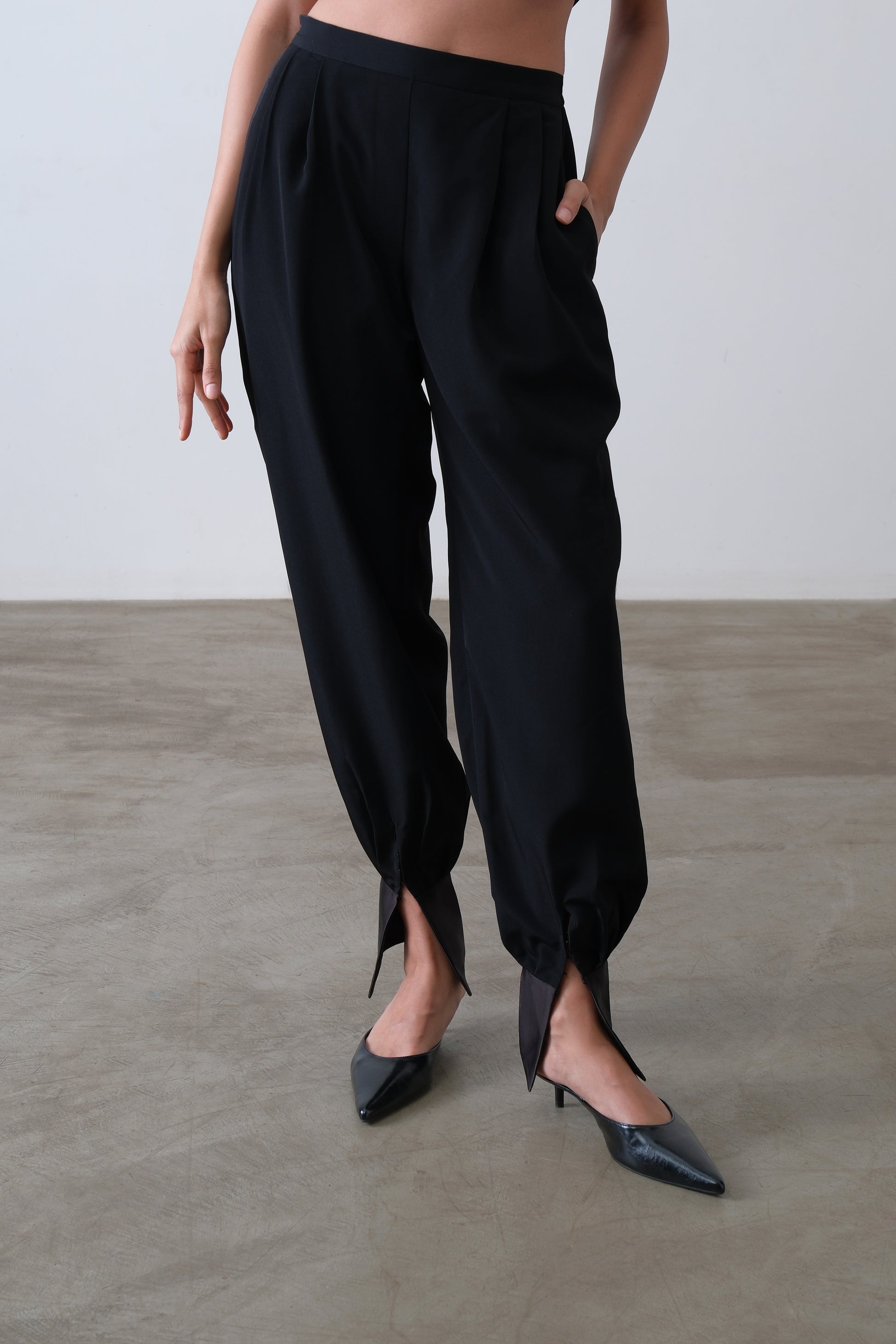 Black viscose blend pleated trousers with tapered leg and satin ankle cuff