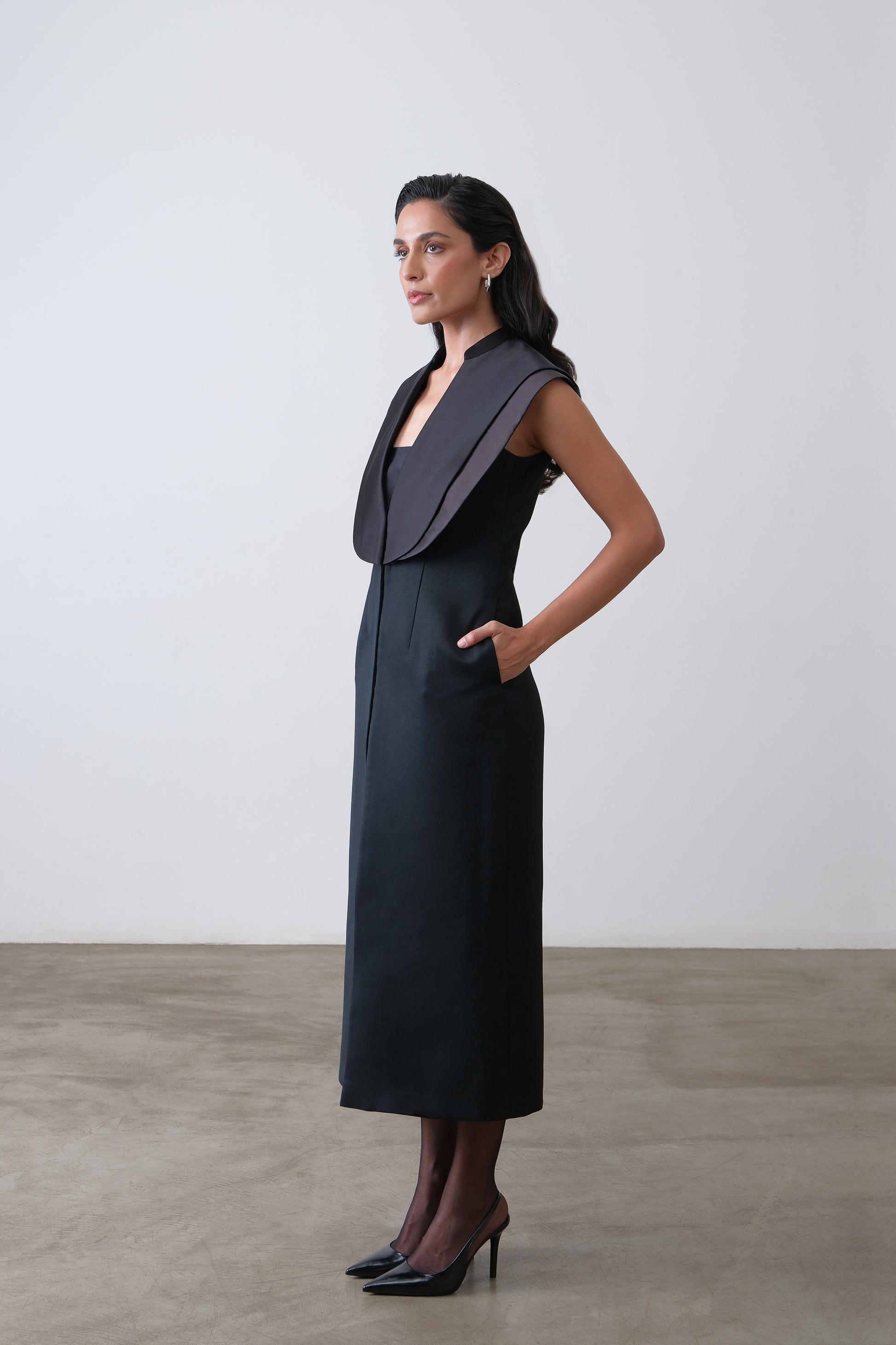 Side view of black midi dress with double satin collar and slit