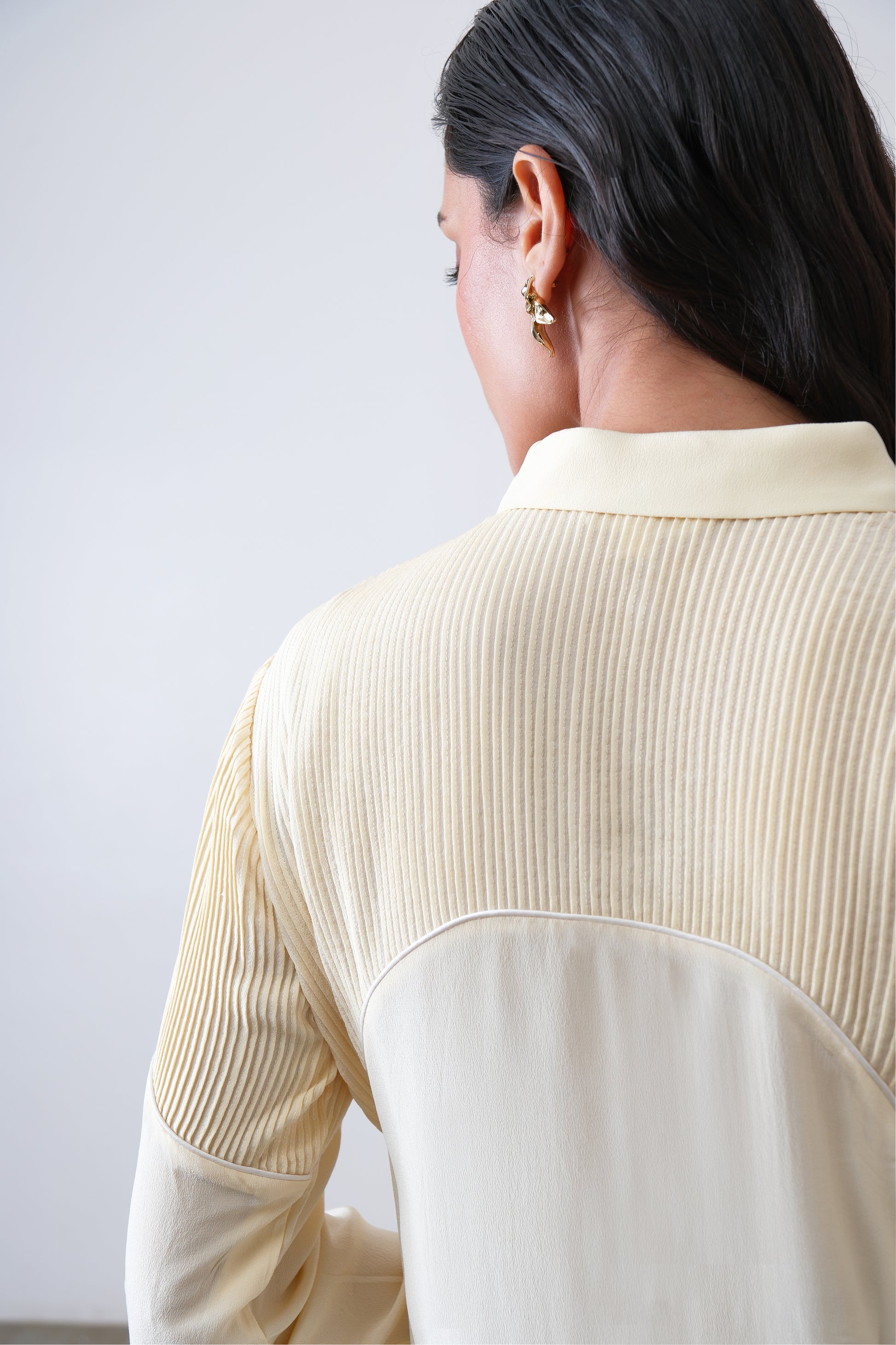 Close up of hand tucks and ivory piping on butter yellow silk crepe shirt