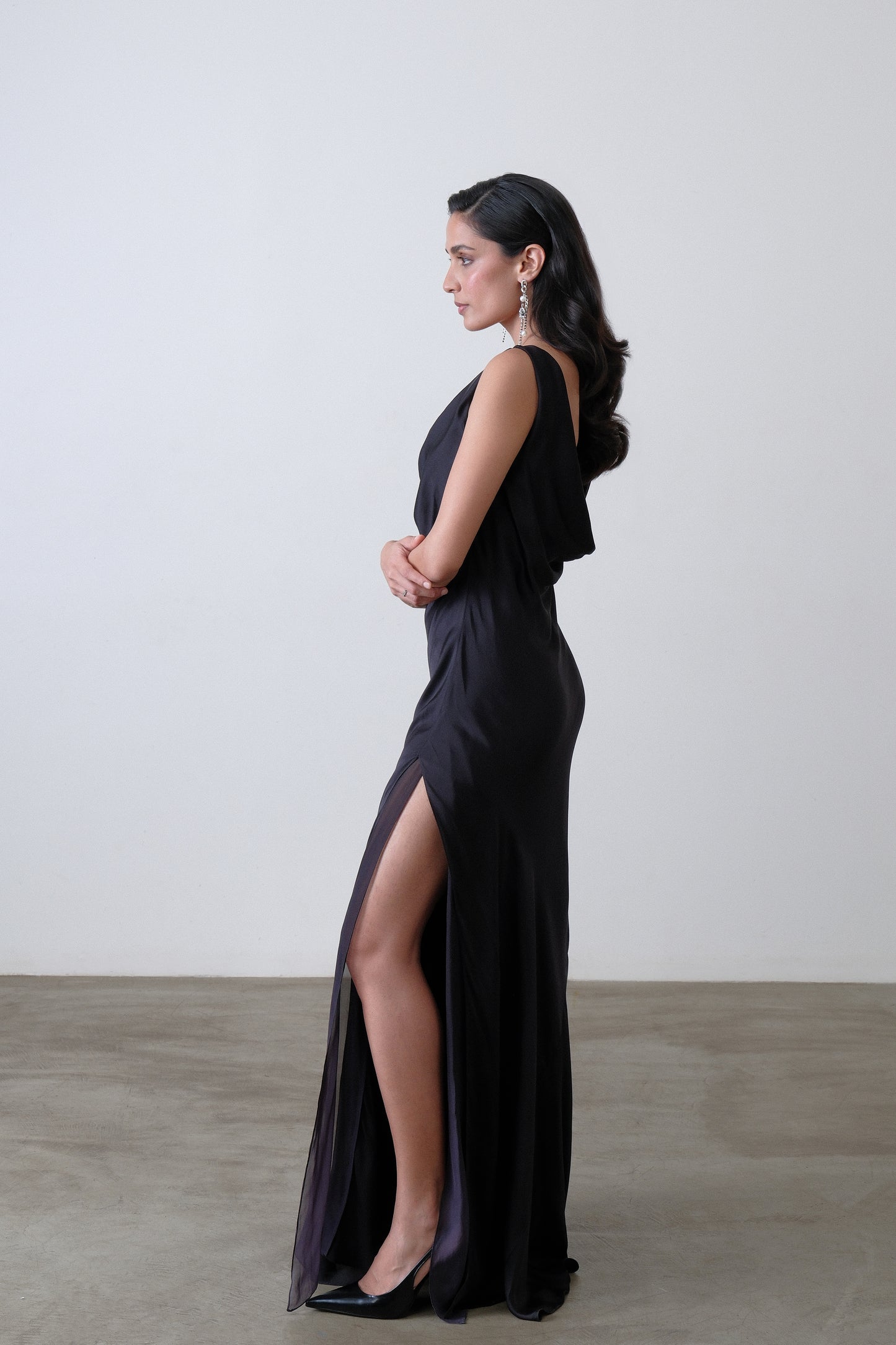 Side view of charcoal silk satin georgette dress with high slit and panel detail