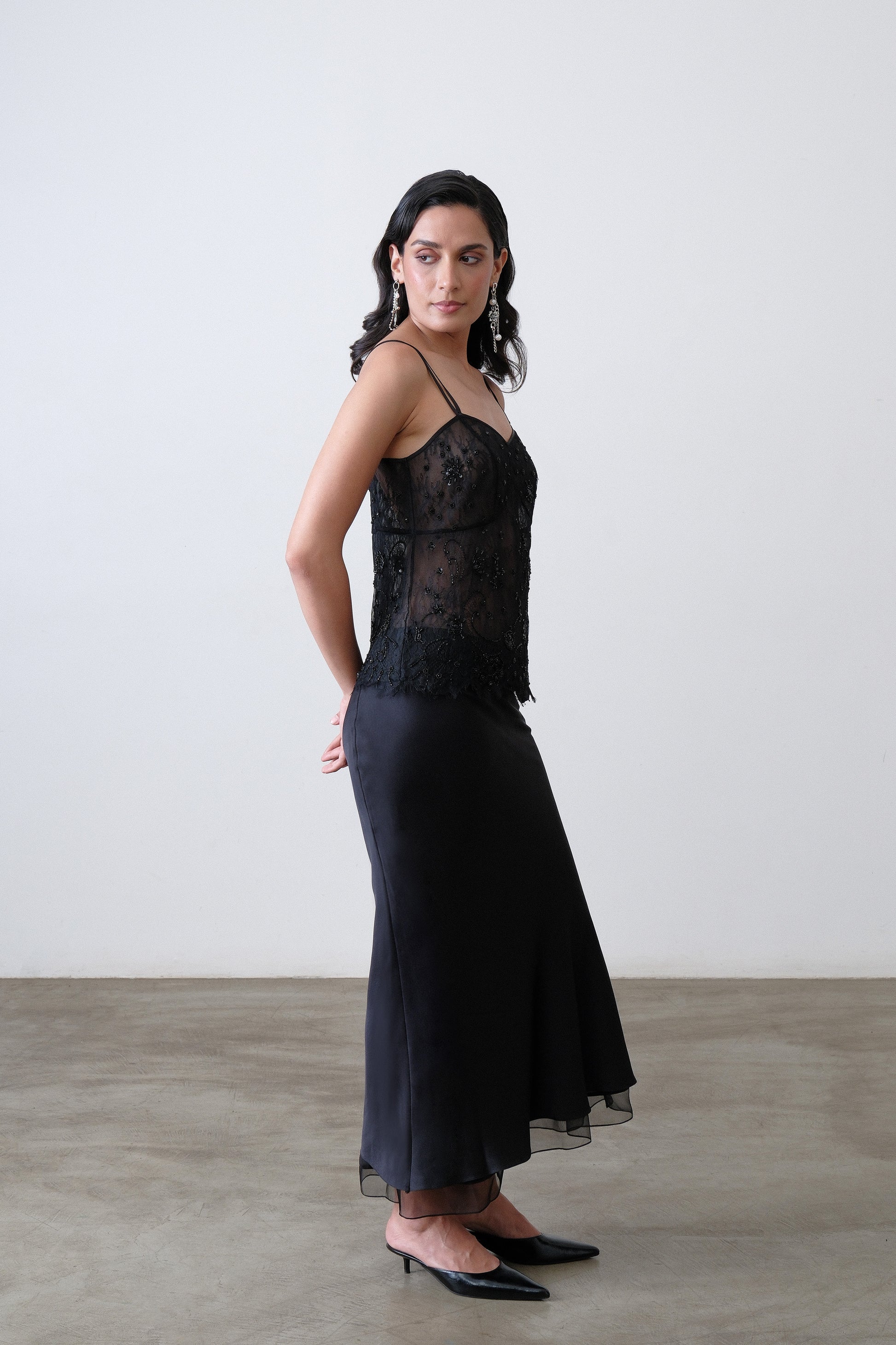 Side view of black silk satin bias skirt with organza hem detail
