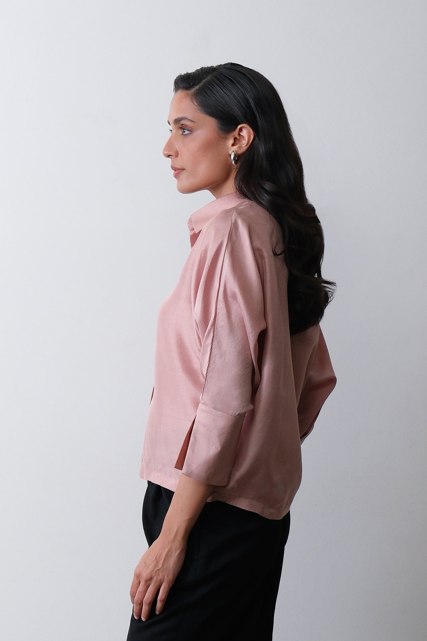 Side view of dusty pink dupion silk shirt with turned up cuffs