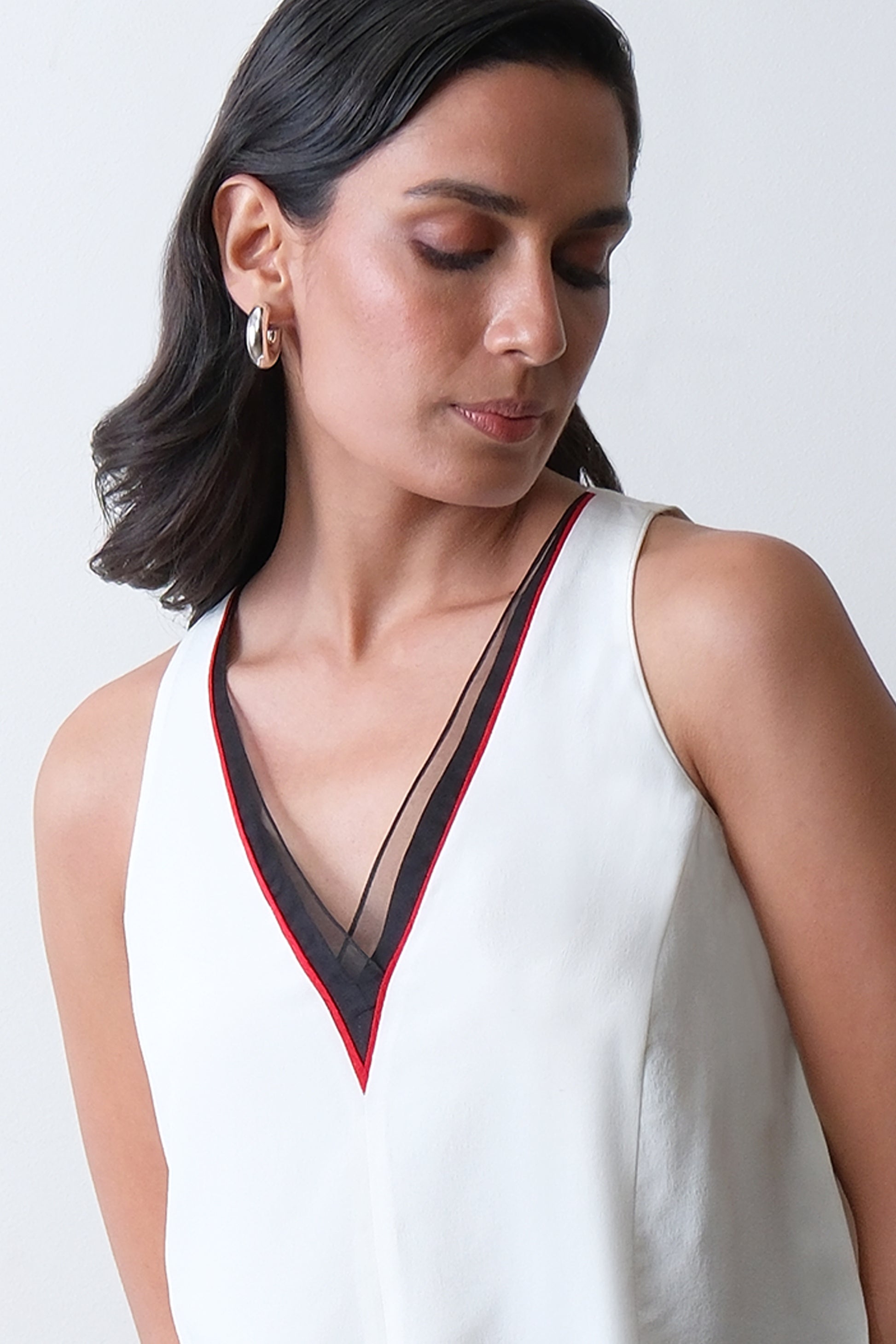 Close up of organza neckline with red piping on ivory silk crepe top