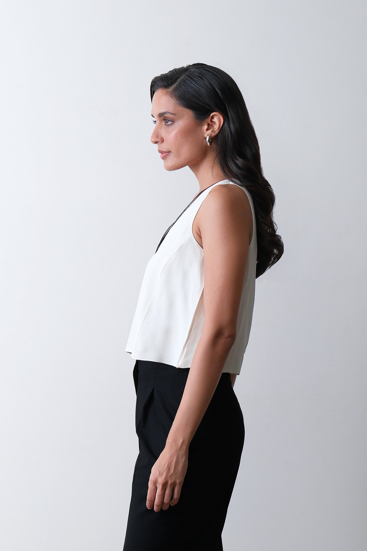 Side view of ivory silk crepe top with contrast piping and clean cut